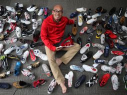 Jay Li, gerente internacional de  Li-Ning International sentado entre zapatos de su compañía. AP  /