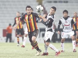 Diego Esqueda (7) disputa un balón con el jugador de Tijuana durante el partido de ayer. EL INFORMADOR  /