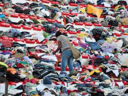 Una mujer elige prenda entre cientos de pilas de ropa para los damnificados, en Teresópolis. EFE  /