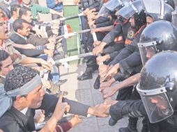 Inconformes y policías antimotines chocan en el Centro de El Cairo. REUTERS  /