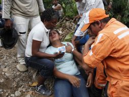 Rescatistas confortan a la esposa de un minero, luego de saber que es uno de los fallecidos en la explosión en el yacimiento. EFE  /