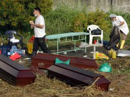 Empleados de la morgue de Sardinata limpian los féretros de tres de los 21 mineros muertos. EFE  /