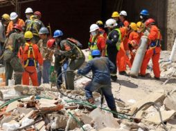 Bomberos y  rescatistas buscan sobrevivientes en medio de las ruinas. AFP  /
