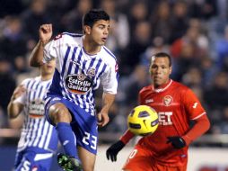 El defensa del 'Depor', Aythami, intenta controlar el balón ante el delantero del Sevilla, Luis Fabiano. EFE  /