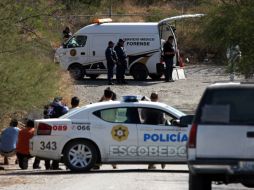 Peritos de la Procuraduría y oficiales de la Agencia Estatal de Investigaciones levantan los cuerpos de seis personas calcinadas. NTX  /