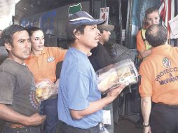 Agentes del Instituto Mexicano de Migración orientan a ilegales para abordar el autobús que los llevará de retorno a sus países. AFP  /