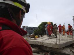 Trabajadores intentan rescatar a las personas atrapadas tras una crecida de un río al sur de Bolivia. AP  /