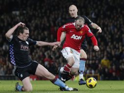 Wayne Rooney lucha por el balón con dos jugadores del Aston Villa. REUTERS  /