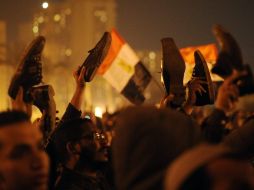 Ciudadanos levantan sus zapatos en la plaza Tahrir de El Cairo en protesta contra la negativa del presidente de renunciar. EFE  /