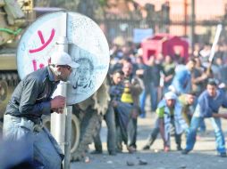 Manifestante se esconde de los partidarios del Gobierno de Hosni Mubarak, presidente de Egipto. AP  /