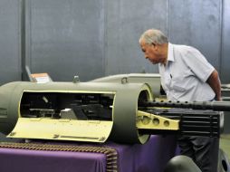 Un hombre observa una ametralladora exhibida durante la exposición. EFE  /