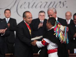 El Presidente Felipe Calderón entrega copias de la Constitución en diferentes dialectos a indígenas. EFE  /