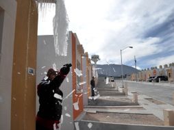 Un residente de Coahuila retira el hielo formado en la cañería de su casa. EFE  /