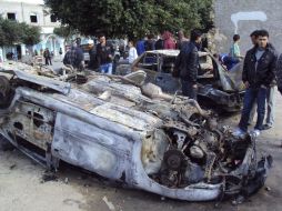 Tunecinos inspeccionan dos autos quemados, resultado de un choque entre manifestantes y policías en la región de Sidi Bouzid. EFE  /