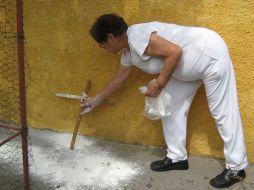 Una vecina de la calle Del Progreso coloca una cruz en el lugar donde murió Vicente Espinoza. O. RUVALCABA  /