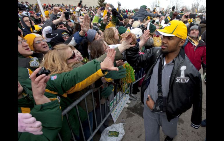 La ciudad sede d ela NFL más chica de Estados Unidos recibió ayer a sus héroes. Charles Woodson saluda a la afición. AP  /