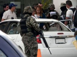 Militares y peritos revisan el vehículo que utilizaban los marinos cuando fueron sorprendidos por un comando armado. EL UNIVERSAL  /