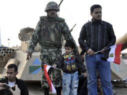 Varios egipcios posan con un soldado en un tanque durante las protestas contra el régimen de Mubarak. EFE  /