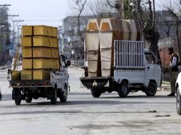 Dos camiones transportan ataúdes al lugar del ataque suicida en Mardan. AP  /