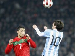Lionel Messi y Cristiano Ronaldo luchan por el control del balón en el duelo amistoso. AP  /