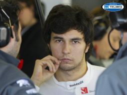 El piloto mexicano Sergio Pérez, de la escudería Sauber, habla con sus mecánicos en boxes después del entrenamiento. EFE  /