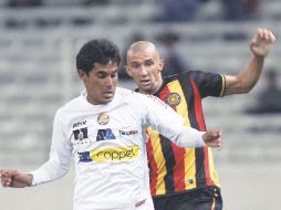 Mario Padilla, de Dorados, protege una pelota ante la marca de Marco Jiménez, de Leones Negros. MEXSPORT  /