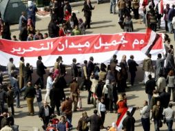 Varias personas muestran una pancarta en la que se puede leer El día de embellecer la plaza Tahrir. EFE  /