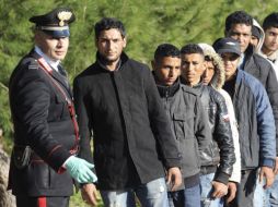 Inmigrantes tunecinos esperan su trasladado a un campamento después de arribar a la isla de Lampedusa. EFE  /