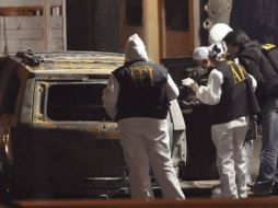 Peritos de la Agencia Estatal de Investigación recaban datos  de los restos del vehículo. AFP  /