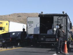 Policías federales resguardan la camioneta en la que viajaban los dos agentes estadounidenses. AFP  /