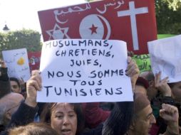 Una mujer porta un cartel en el que puede leerse (en francés) musulmanes, cristianos, judíos, todos somos tunecinos. EFE  /