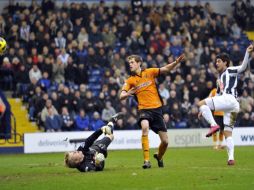 Carlos Vela derribando al portero del Wolverhampton y mandando el esférico al fondo de la red. AFP  /