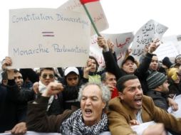 Los manifestantes gritan consignas mientras sostienen  pancartas durante una protesta. AFP  /