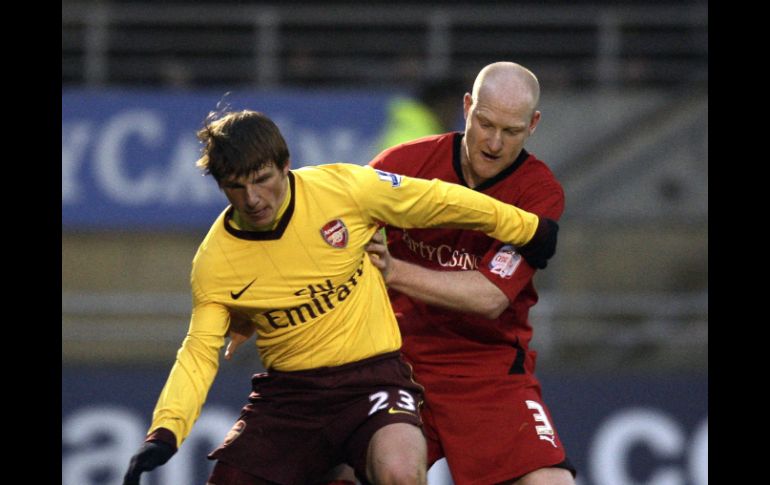 El ruso del Arsenal, Andrey Arshavin, es marcado por el defensa del Leyton, Andrew Whing. AFP  /