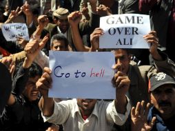 Yemeníes portan carteles en contra del mandatario Alí Abdalá Salé, en Saná.  /