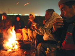 Palestinos combaten el frío tras cruzar el paso fronterizo a Israel, en Eyal, cerca de Cisjordania. EFE  /