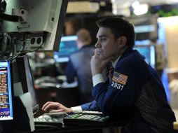 Un corredor trabaja antes del cierre de ayer en Wall Street, la cual se mantuvo en terreno negativo por la crisis en Libia. EFE  /