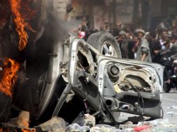 Manifestantes destruyen vehículos del Gobierno yemení, frente a la Universidad de Saná. REUTERS  /