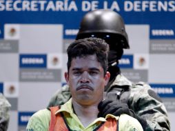 Un soldado escolta a Julián Zapata Espinosa, 'El Piolín', durante la presentación a los medios. AP  /