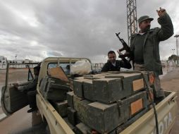 Libios en un vehículo cargado con armamento de una base militar tomada por los manifestantes en la ciudad de Benghazi. AP  /