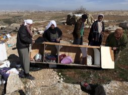 Una familia palestina buscan sus pertenencias en la basura después de que su casa fue destruida por tractores del ejército israelí. EFE  /