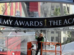 Una mujer del equipo de producción detalla la instalación de una parte  del montaje de la fiesta del cine. AFP  /