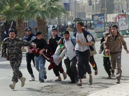 Inconformes con el Gobierno auxilian a una manifestante, en Mosul. AP  /