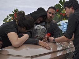 Deudos lloran sobre los ataúdes de Elías y Malena Reyes Salazar. AP  /