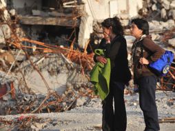 Afectados inspeccionan los escombros dejados por el tsunami causado por el temblor de 8.8 grados que se presentó un día antes. AFP  /