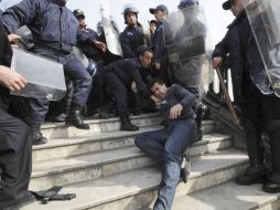 Policías antidisturbios se enfrentan a un manifestante durante una protesta convocada en Argel. EFE  /