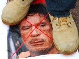 Un  manifestante pisa una foto de Muamar Gadhafi. AFP  /