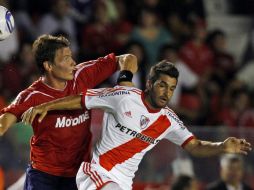 Maxi Velázquez, del Independiente, pelea un balón con Paulo Ferreri, de los Millonarios. AP  /
