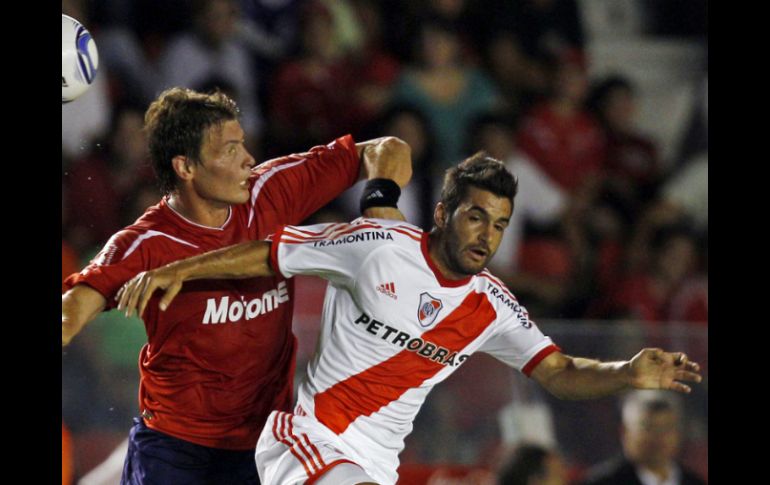 Maxi Velázquez, del Independiente, pelea un balón con Paulo Ferreri, de los Millonarios. AP  /