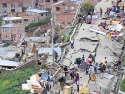 Algunas familias rescatan sus pertenencias luego de quedar sin vivienda. EFE  /